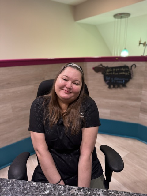 woman smiling sitting in an office chair